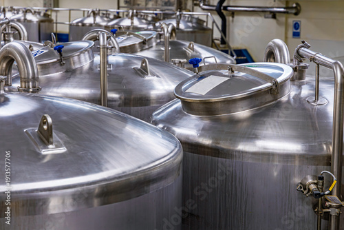 Photos Stainless vertical steel tanks and pipes with pressure meter in equipment tank c