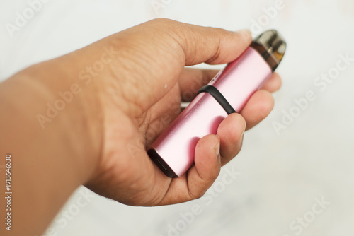Hand Holding Pink Vape Device