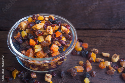 Foto Dried mixed fruit in a glass bowl on wooden table.