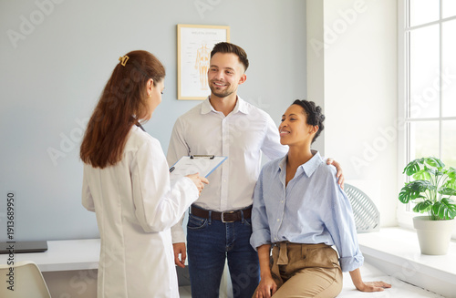 Photos Multiethnic positive couple listening female doctor sharing health advices related to pregnancy, infertility, or reproductive health