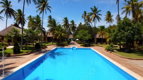 4K video of a tropical resort pool surrounded by palm trees