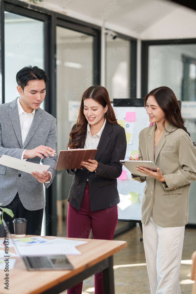 © aekachai - Group of young Asian professionals engaging in a dynamic brainstorming session. A female leader stands confidently while presenting ideas to her colleagues, showcasing a collaborative, positive © aekachai - Group of young Asian professionals engaging in a dynamic brainstorming session. A female leader stands confidently while presenting ideas to her colleagues, showcasing a collaborative, positive