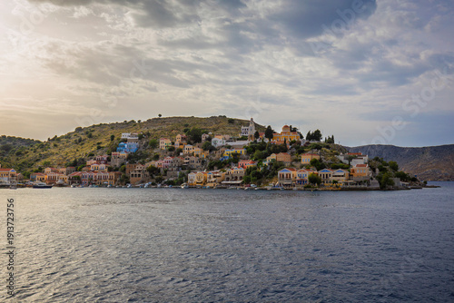 Colorful buildings on a hillside in the idyllic town of Symi by the Aegean Sea on Symi (Simi, Syme) island in Greece on a cloudy day.