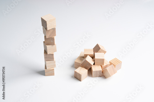 Slika na platnu a neat pile of rough wooden cubes and a messy pile