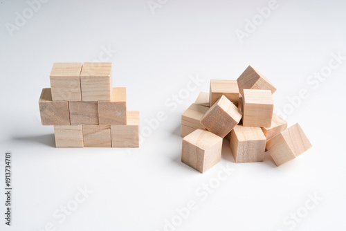 Fotografija a neat pile of rough wooden cubes and a messy pile