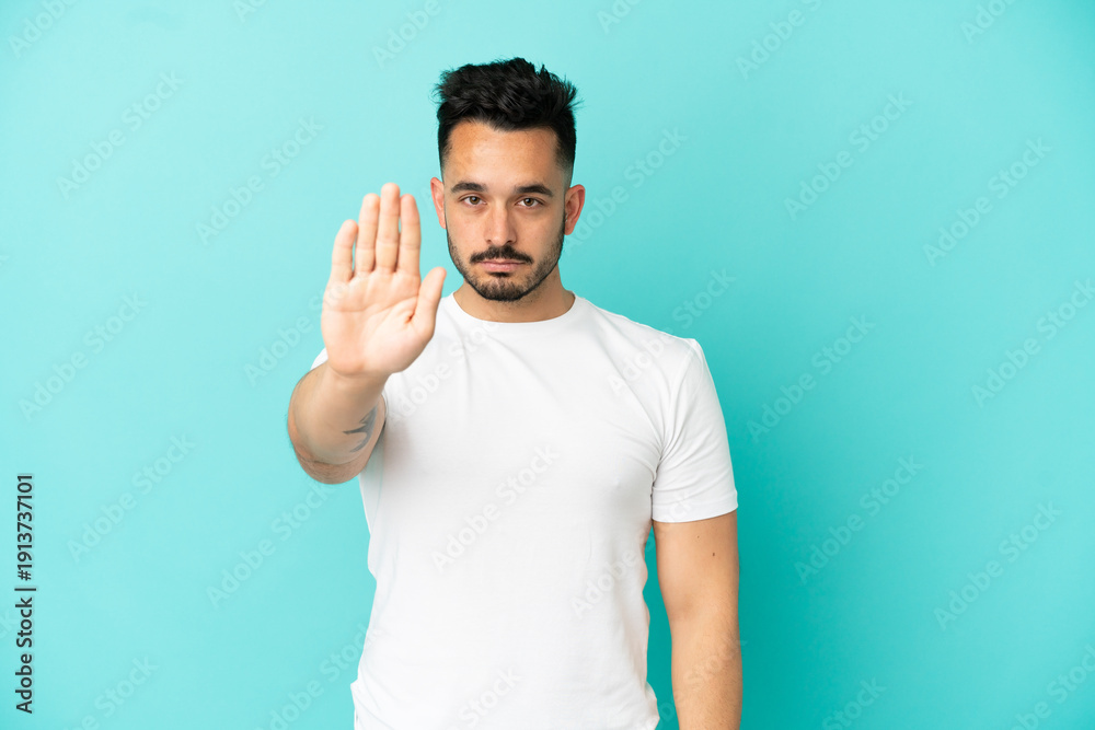 Fototapeta premium Young caucasian man isolated on blue background making stop gesture