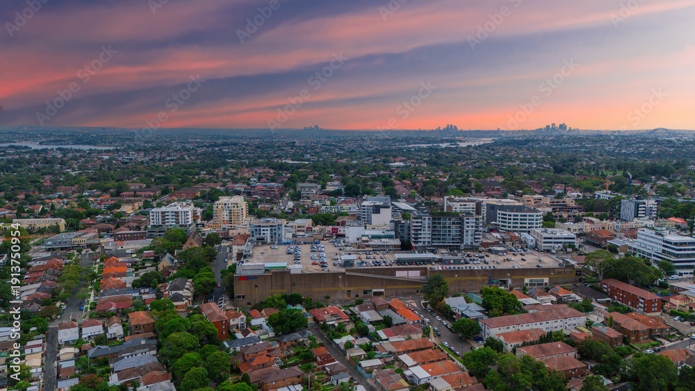 Fototapeta premium Panoramic Aerial Drone view of Inner Western Suburbs of Sydney housing, roof tops, the streets and the parks, the roads and trees of Ashbury Ashfield Burwood Summer Hill Canterbury and Campsie in Sydn