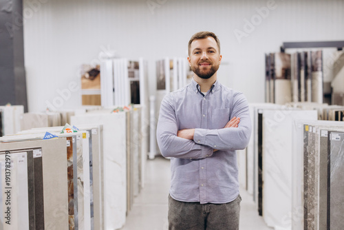 Bilde på lerret Confident store owner standing in building materials showroom, arms crossed, pro