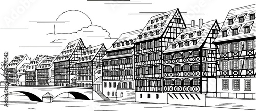 Medieval European townhouses line a canal with a bridge and sun