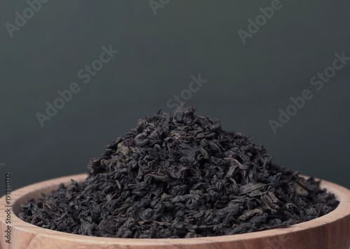 Premium loose leaf black tea in wooden bowl with copy space