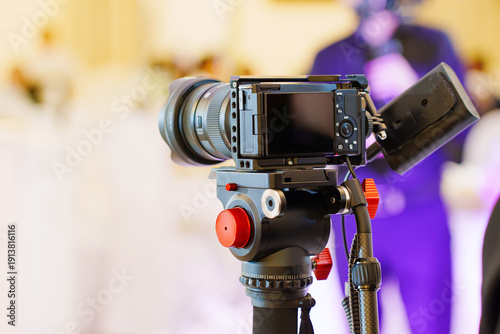 Camera set on a tripod at an event venue during a gathering