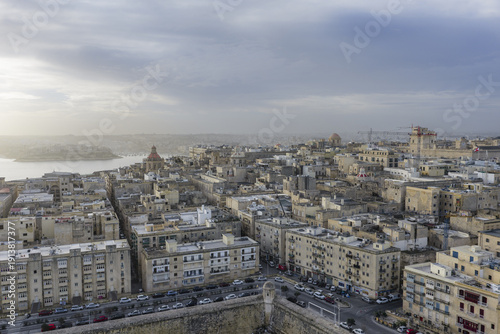 Aerial view of historic buildings basking in the fading sunlight, with a glimpse of the sea in the distance, Valletta, Valletta, Malta.