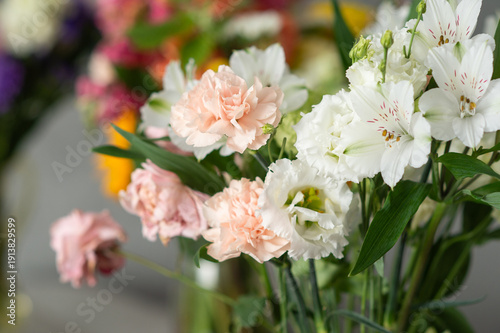 Close-up of white and pink flowers with green leaves in vibrant bouquet