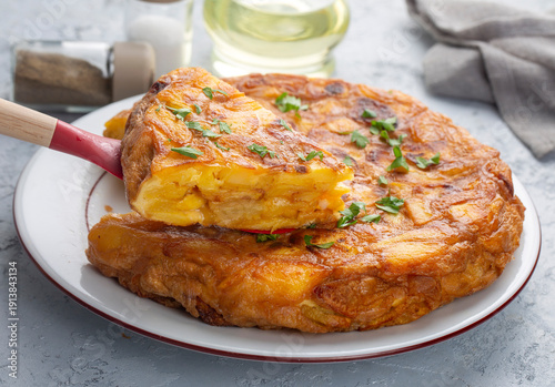 Konstfotografi Spanish omelette with potatoes, typical spanish cuisine on gray concrete floor