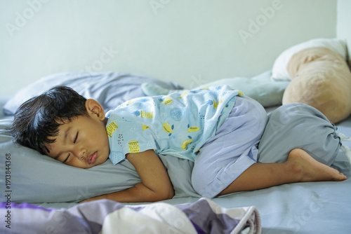 Cuadro en lienzo Young child sleeping peacefully on stomach while hugging a bolster pillow on bed