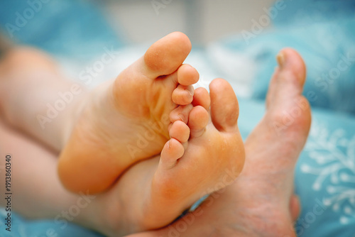 Wallpaper Mural Casual, not perfectly groomed feet resting on each other on a bed during relaxation. Everyday comfort and rest. Torontodigital.ca