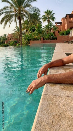 Feet resting on the edge of a swimming pool, tropical resort setting, relaxation moment, vacation leisure, serene atmosphere.