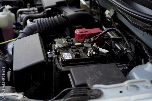 Detailed View of a Car Battery and Engine Components Under Natural Light