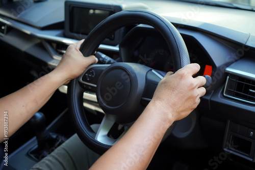 Close-up of hands on the steering wheel while driving a car