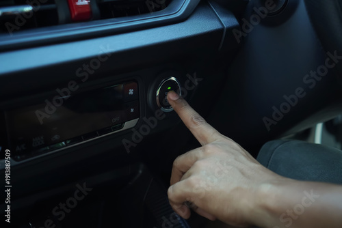Person Finger Pushing Start Button Inside A Modern Car Interior With Green Illuminated Indicator