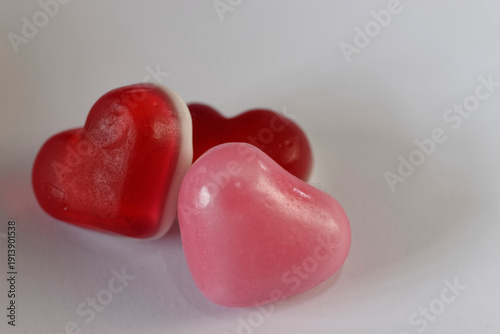 Trio of Red and Pink Gummy Candy Hearts on White