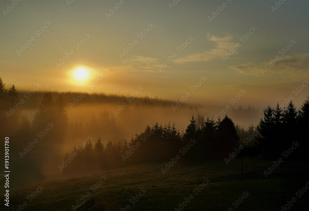 Obraz premium Beautiful view of the sunrise in the mountains, the landscape is covered in fog.