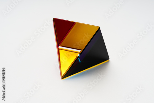 Abstract Gold and Red Glass Pyramid 3D Render Floating on Light Background