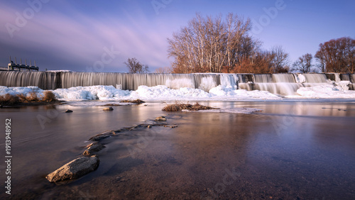 Canvas Print Winter weir at Cvrcovice with ice cascades in warm light