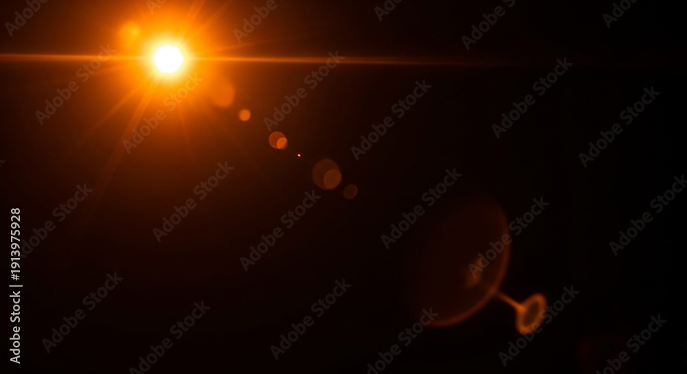 Fototapeta premium Bright Orange Lens Flare Effect with a Black Background and Bokeh Circles