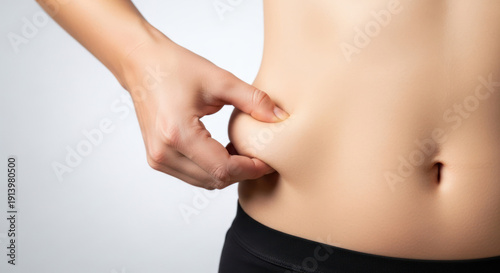 Close-up of a person pinching abdominal fat on their side.