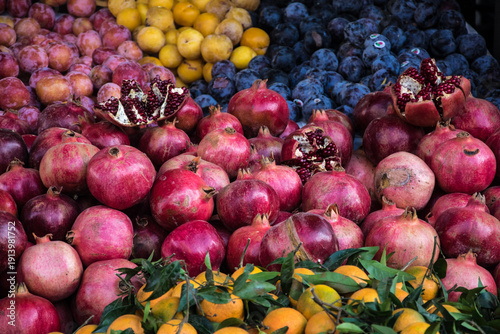 Close-up of pomegranates, mandarins and plums on Moroccan market stall