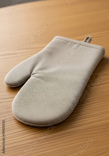 Oven mitt on a wooden table waiting for culinary adventures to unfold