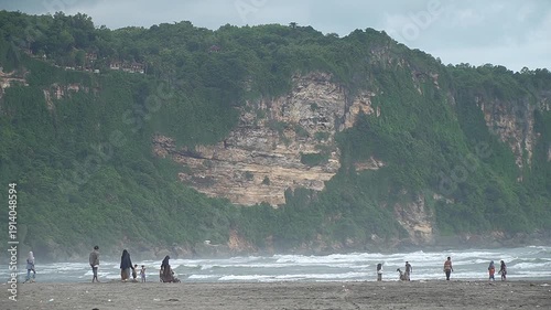 Vibrant Crowded Beach Atmosphere at the Foot of a Hill