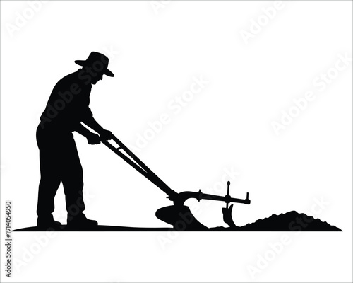 Silhouette of a man using a tiller to cultivate soil