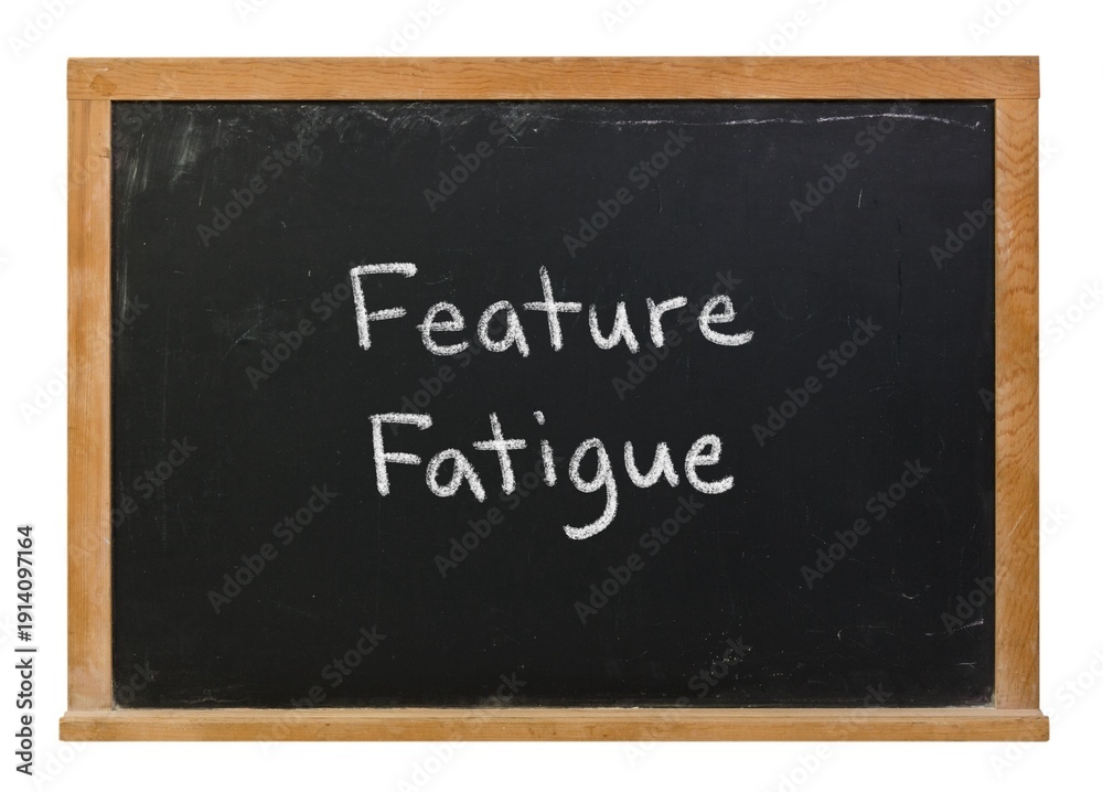 Obraz premium Feature Fatigue hand written in white chalk on a black chalkboard isolated on white in a wooden frame