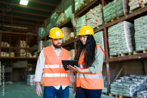 Bild auf Leinwand Warehouse workers collaborating on inventory management using a digital tablet i