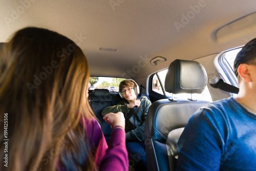Foto Family road trip with a mother asking teen boy to wear his seatbelt and a girl i