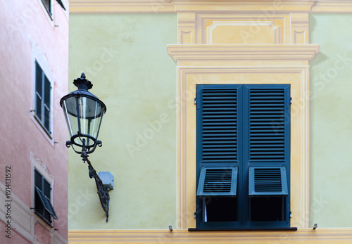 Part of a typical ligurian ornate painted building with street lamp in Chiavari near Genova