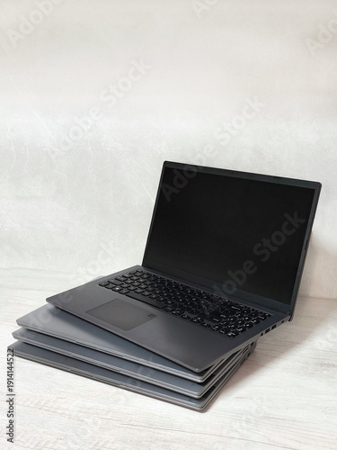 stack of laptops on a gray background, on the table, laptop computer, tablet, business, work, remote work, freelance.
