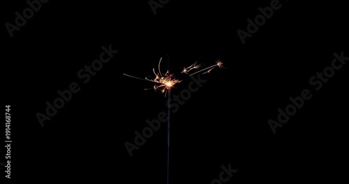 Lightening sparkler on the black background. Sparkler concept. Bengal lights are burning on a black background. Holiday party concept. New year party sparkler. Slow motion.