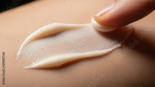 Close-up of a hand applying cream to the skin for moisturizing and care.