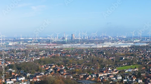 vista vast industrial horizon seaport ghent dominated by dense forest wind turbines large cooling tower sprawling logistics wide angle drone shot of belgium 