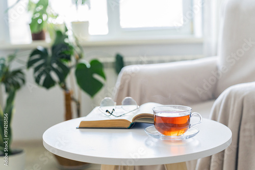 Quadro su tela Relaxing with tea and reading a book indoors