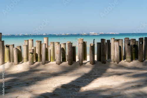 a makeshift bamboo fence is driven into the sand and create a walking path that does not stray too far away from the beach