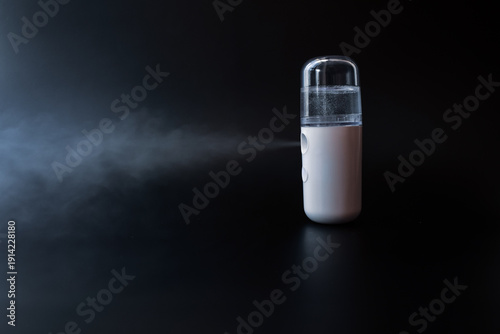 Photos Portable Air Humidifier Emitting Mist on Dark Background