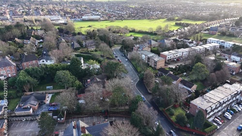 Aerial forward motion over winter rooftops, leafless trees and chimney smoke rising from homes in Wirral, Merseyside. Perfect for seasonal editorial use, community features and atmospheric B‑roll.