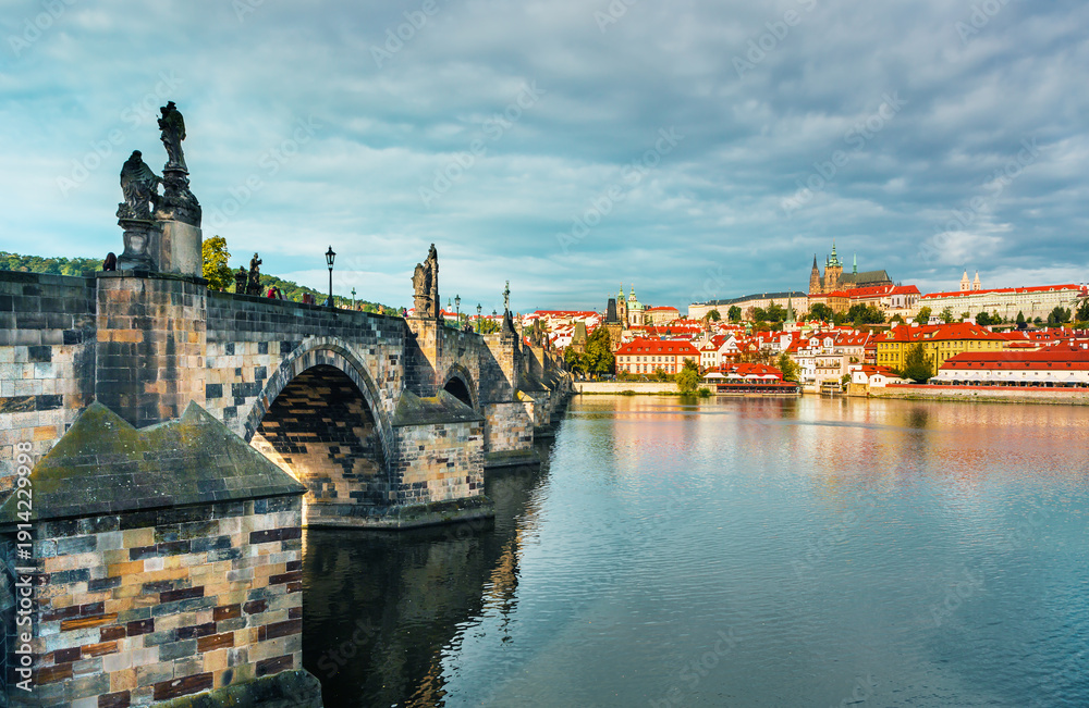 Fototapeta premium Charles Bridge (Karlův most) in Prague, Czech Republic, spanning the Vltava River with historic towers and Gothic architecture. Panoramic view of the medieval bridge and city skyline, iconic European 