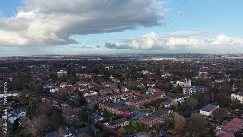 Cinematic aerial tracking shot moving over suburban housing, green spaces and tree‑lined roads in Wirral, Merseyside. Suitable for planning proposals, environmental studies and regional development co