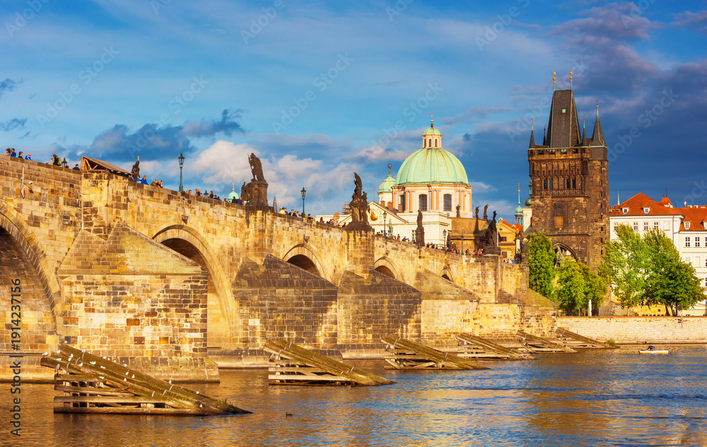 Fototapeta premium Charles Bridge (Karlův most) in Prague, Czech Republic, spanning the Vltava River with historic towers and Gothic architecture. Panoramic view of the medieval bridge and city skyline, iconic European 