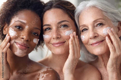 Close-up beauty portrait of three diverse women applying face cream, skincare concept 